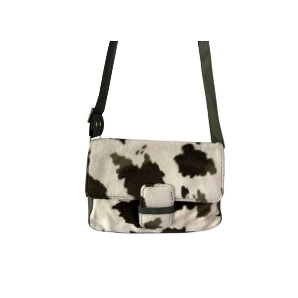 Cow print crossbody bag on a white background