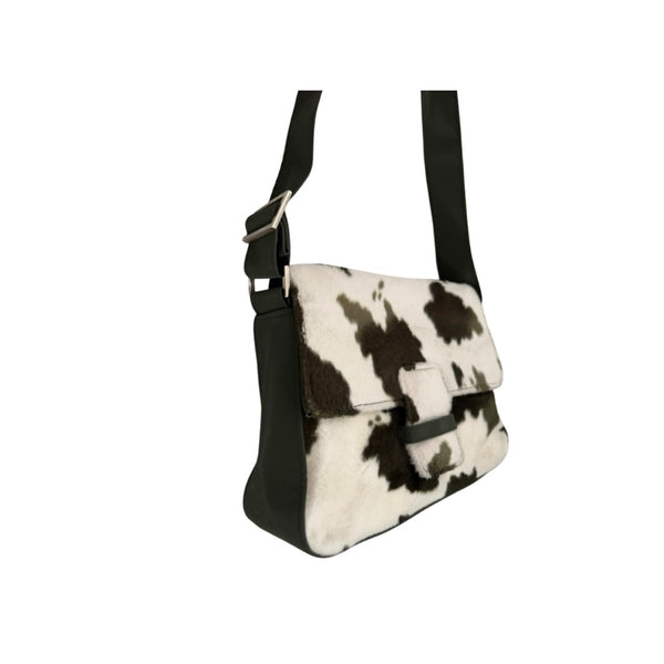 Black and white cow print bag on a white background