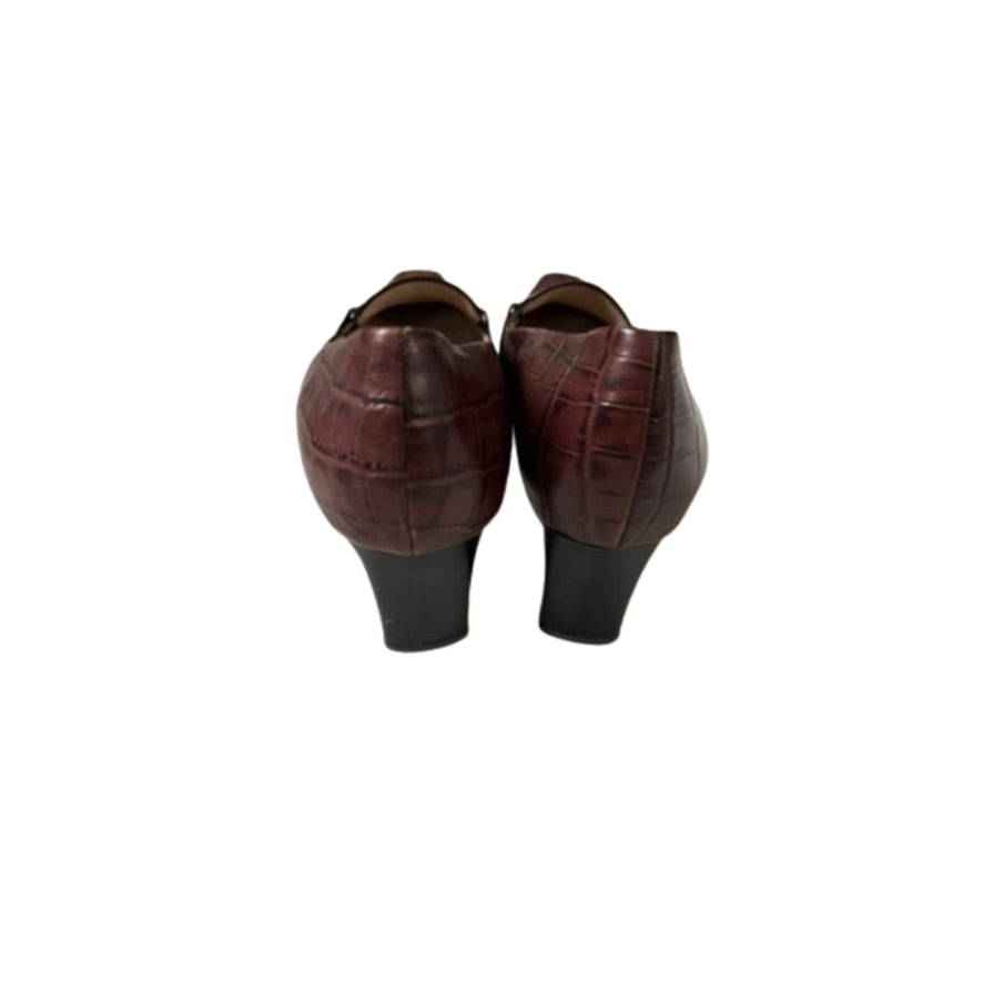 Pair of brown crocodile-patterned shoes on a white background