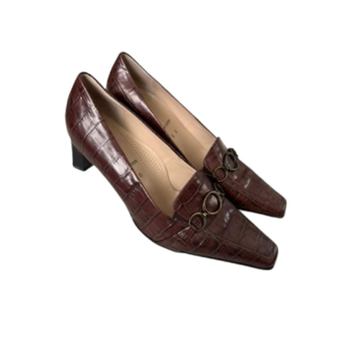 Pair of brown high-heeled shoes with a decorative buckle on a white background