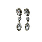 Pair of ornate earrings with clear gemstones on a white background