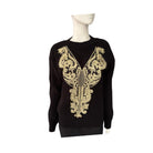 Black sweater with gold embroidery on a mannequin against a white background