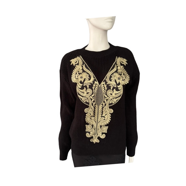 Black sweater with gold embroidery on a mannequin against a white background