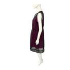 Mannequin wearing a pink dress with sheer black sleeves on a white background