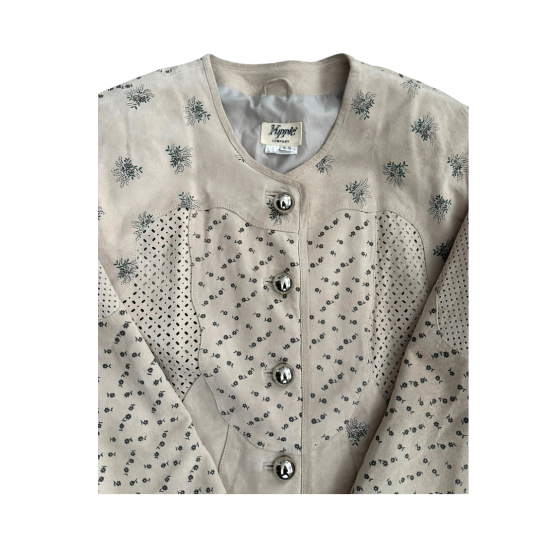 Light-colored blouse with black floral pattern and silver buttons on a white background