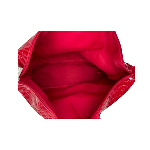 Close-up of a red handbag with a textured surface on a white background