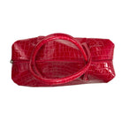 Red crocodile-patterned handbag on a white background