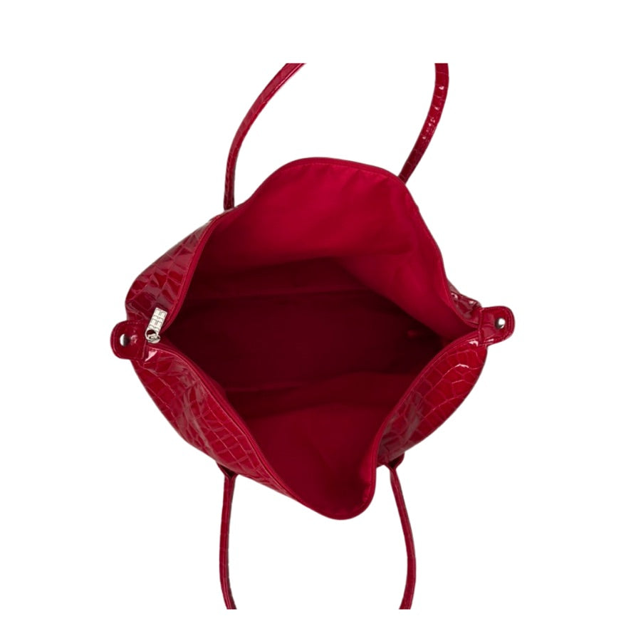 Red handbag with a textured surface on a white background