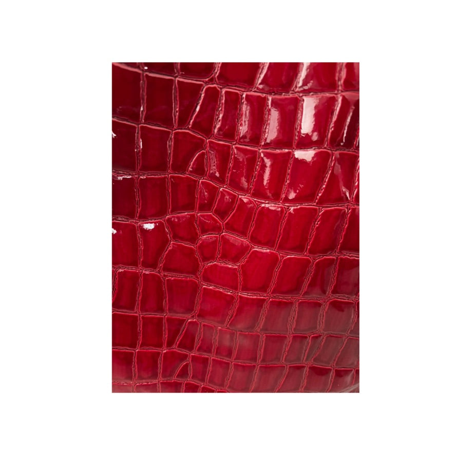 Close-up of red crocodile skin texture on a white background