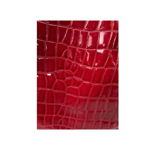 Close-up of red crocodile skin texture on a white background