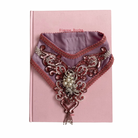 Decorative collar with intricate patterns on a pink book
