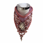 Decorative pink collar with intricate embellishment on mannequin neck on a white background