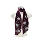Burgundy scarf with decorative elements on a mannequin against a white background
