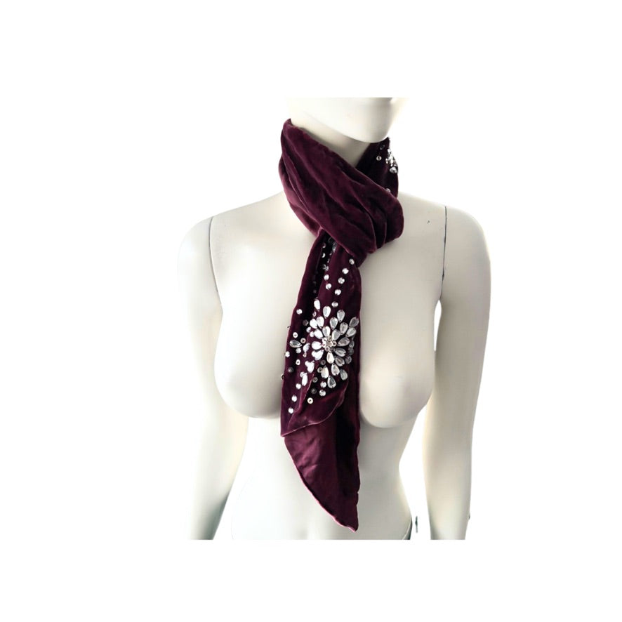 Mannequin wearing a burgundy scarf with silver embellishments on a white background
