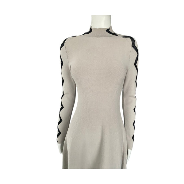Beige dress with black accents on a mannequin against a white background