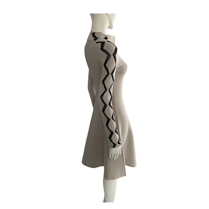 Beige dress with black zigzag pattern on a mannequin against a white background