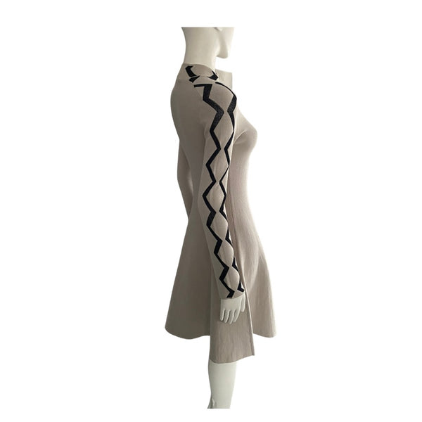 Beige dress with black zigzag pattern on a mannequin against a white background