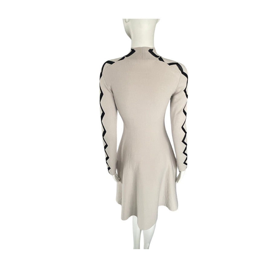 Beige dress with black trim on a mannequin against a white background