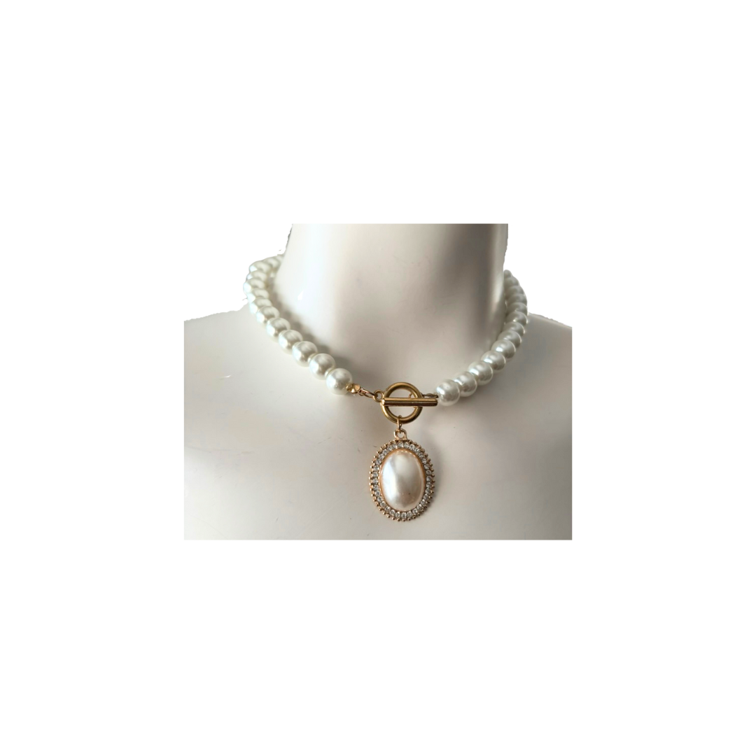 Pearl necklace with a gold clasp on a mannequin against a white background