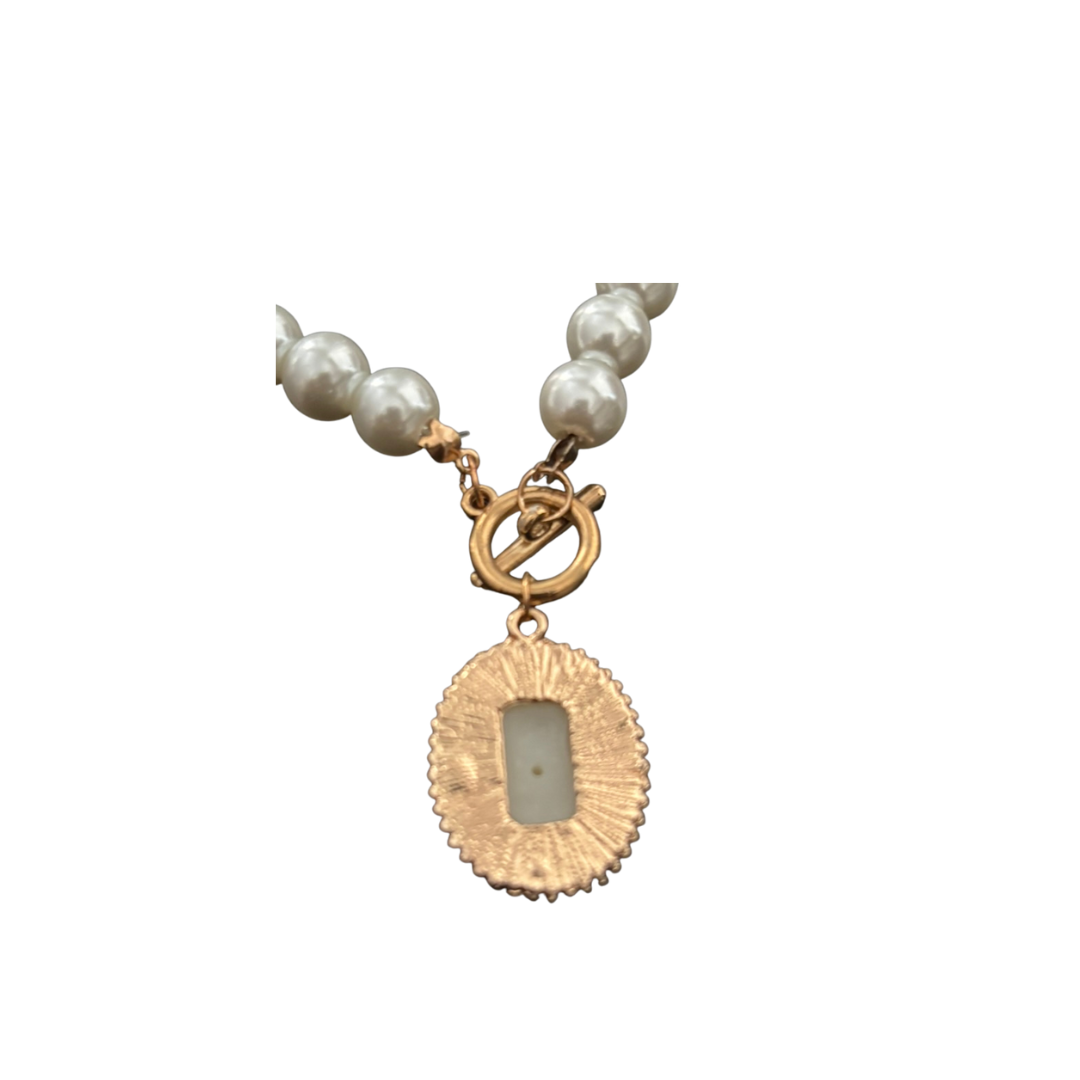 Pearl necklace with a gold pendant on a white background