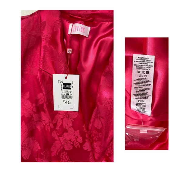 Pink floral shirt with size label and care instructions on a white background