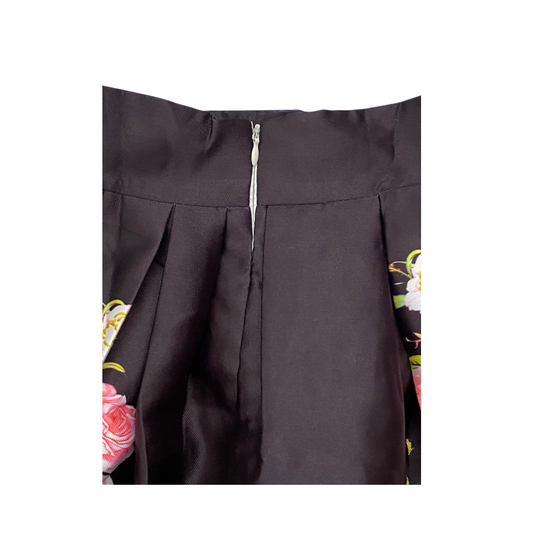 Black garment with floral embroidery on a white background
