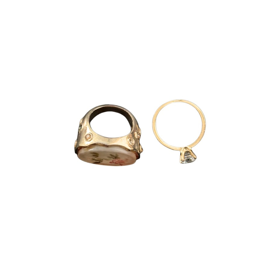 Gold ring and gold earring on a white background