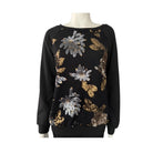 Black sweater with gold and silver floral patterns on a mannequin against a white background
