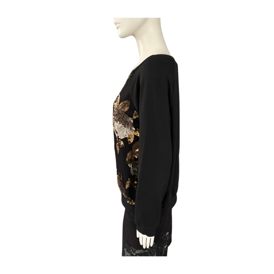 Black top with floral embroidery on a mannequin against a white background
