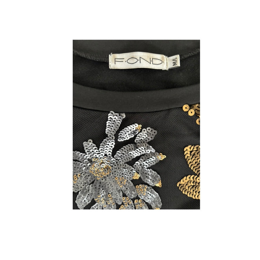 Black fabric with gold and silver sequin floral patterns and a visible brand label.