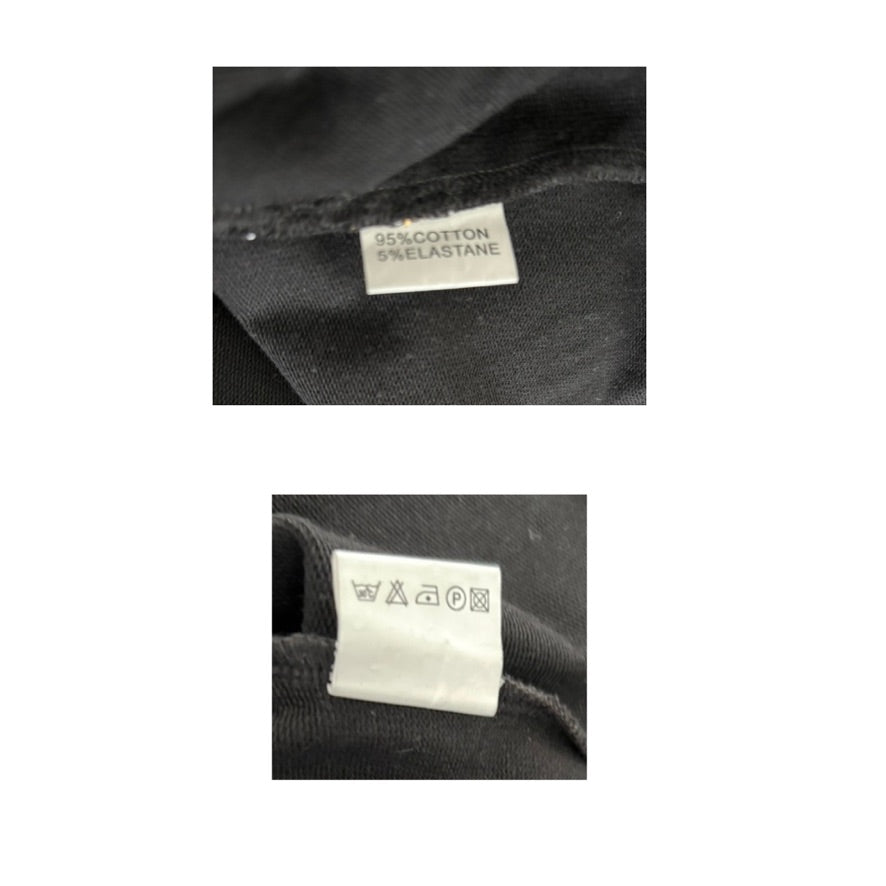 Close-up of fabric labels on a black garment with text and symbols.