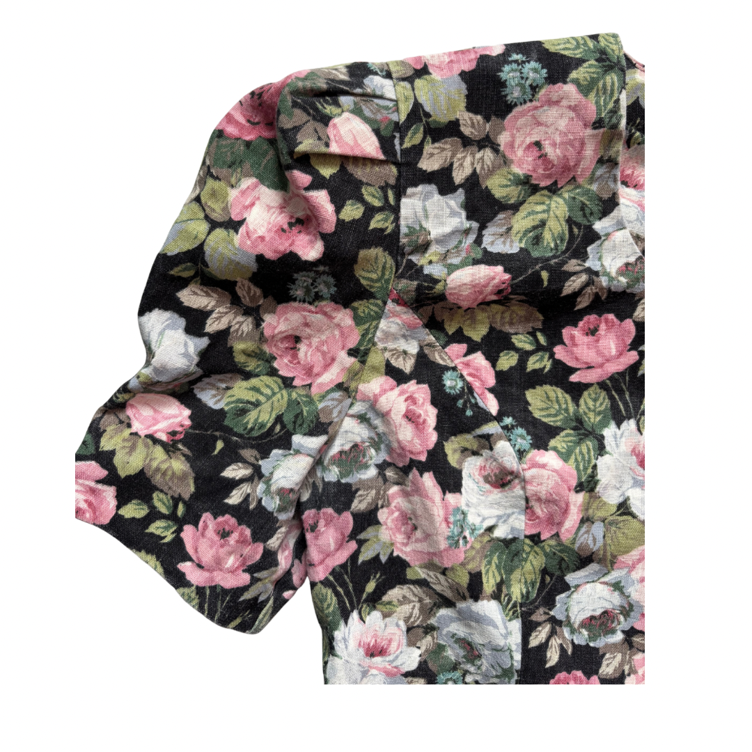 Floral patterned sleeve with pink, white, and green flowers on a black background