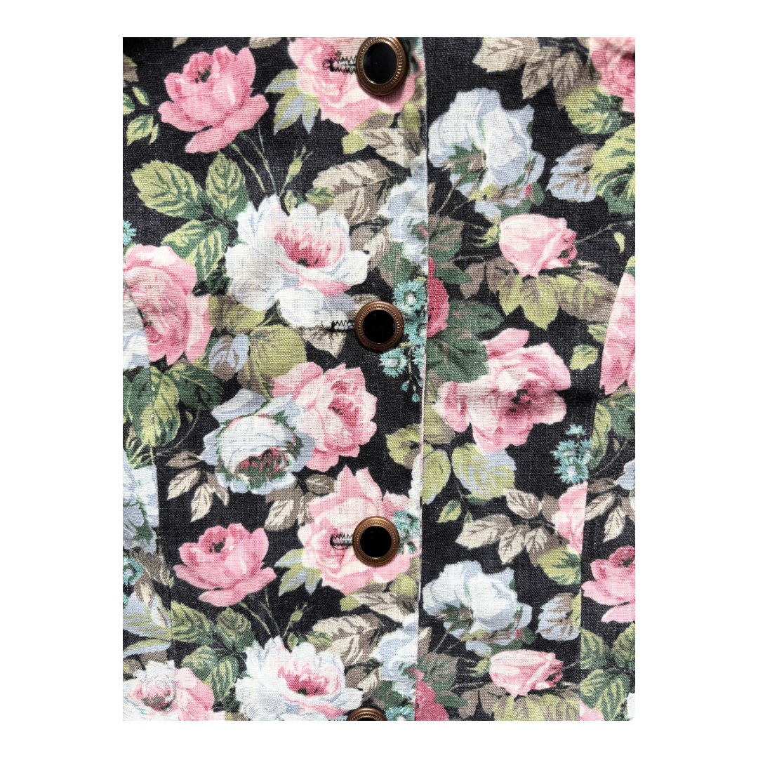 Floral patterned fabric with pink and white flowers on a black background
