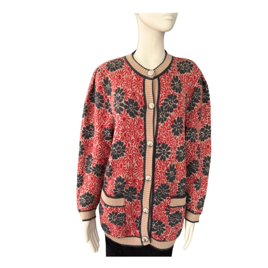 Red and black patterned cardigan on a mannequin against a white background