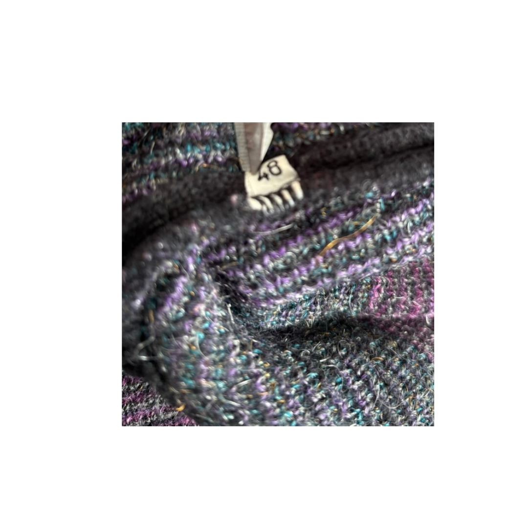 Close-up of a textured fabric with a zipper, showing brand name 'Chanel'.