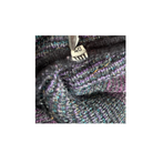 Close-up of a textured fabric with a zipper, showing brand name 'Chanel'.