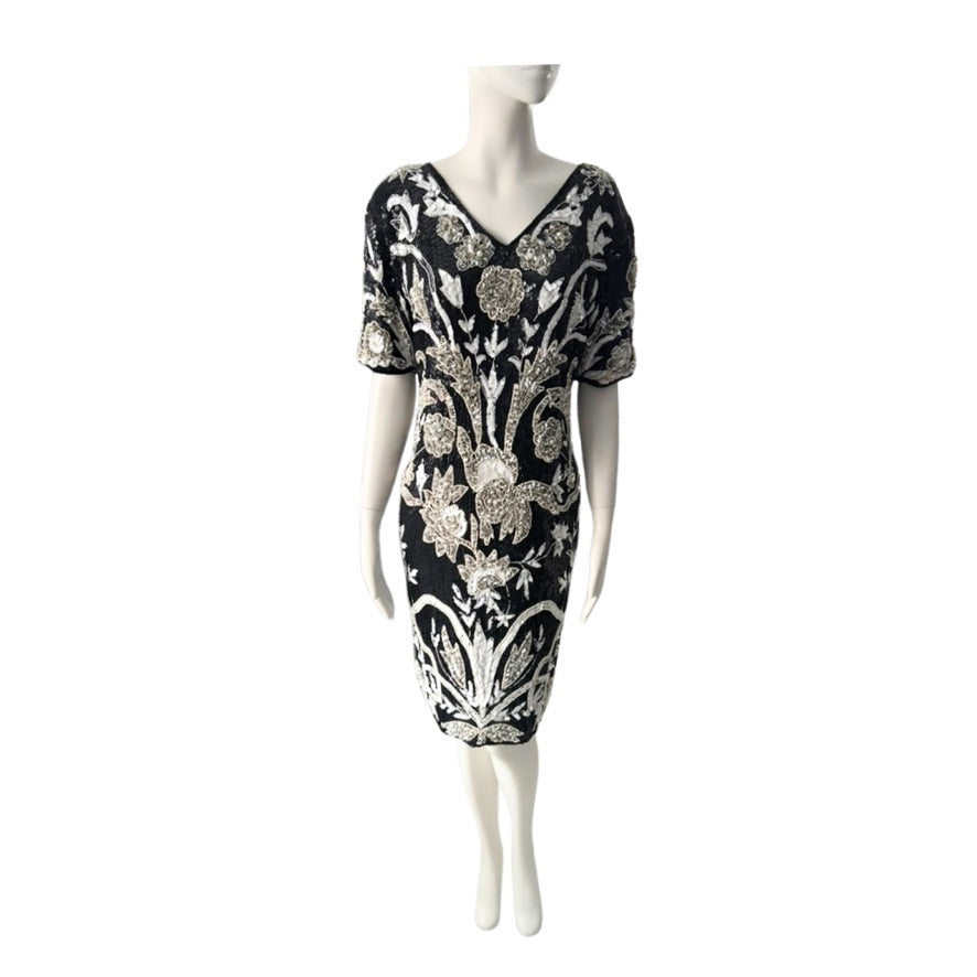 Black dress with white floral pattern on a mannequin against a white background