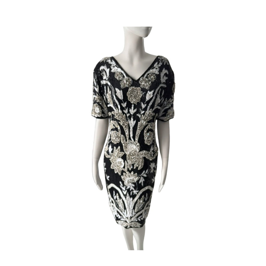Black dress with silver floral patterns on a mannequin against a white background