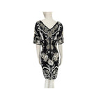 Black dress with white floral patterns on a mannequin against a white background