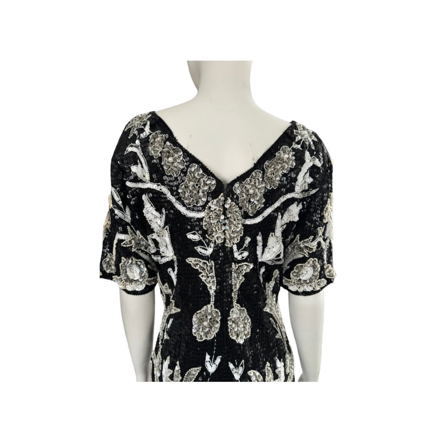 Black dress with floral patterns on a mannequin against a white background