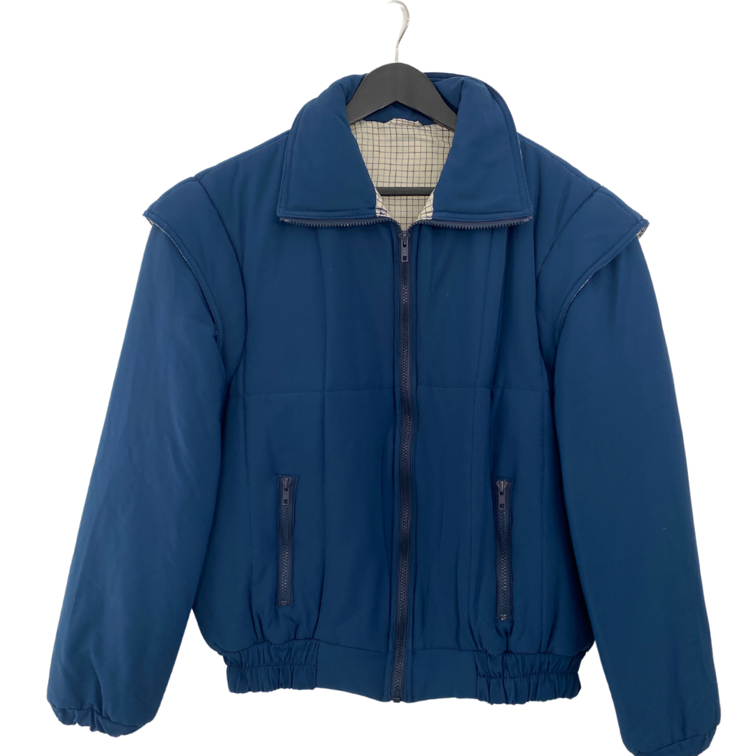 A vintage blue jacket with a cream check contrast collar lining, zip front fastening, and elasticated hem and cuffs. It features padded detailing and has a size XL label.