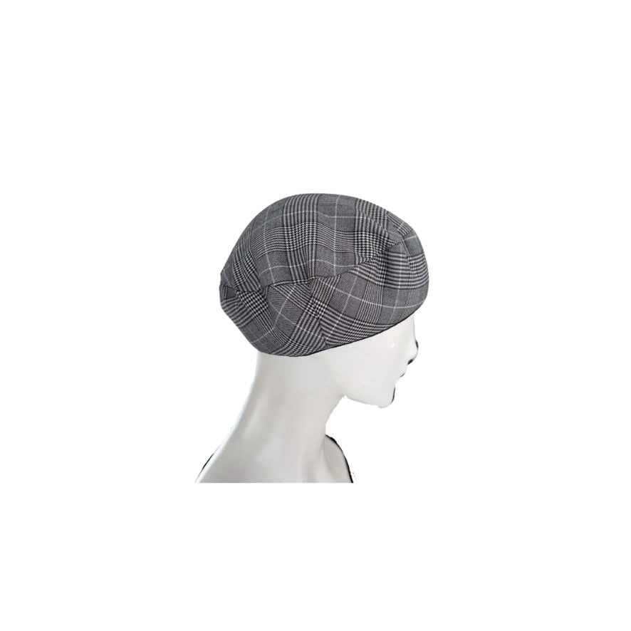Gray checkered beret on a mannequin head against a white background