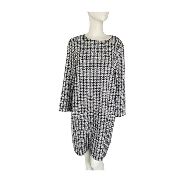 Black and white checkered dress on a mannequin against a white background