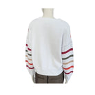 White sweater with colorful striped sleeves on a mannequin against a white background