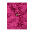 Close-up of a pink textured fabric with ruffled edge and a button on a white background
