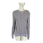 Black and white and lilac checkered sweater on a mannequin against a white background