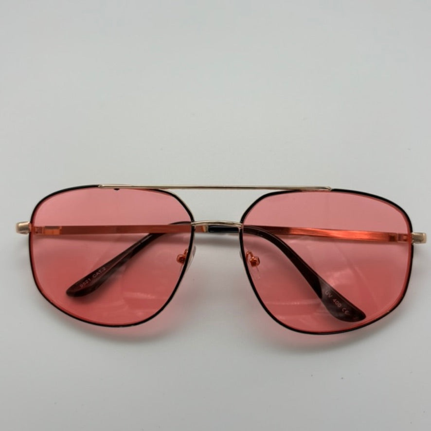 Sunglasses with pink lenses and gold frame on a light gray background