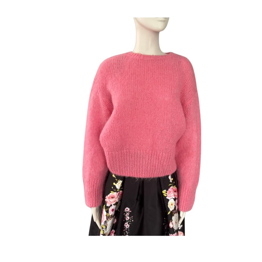 Mannequin wearing a pink sweater with a floral skirt on a white background
