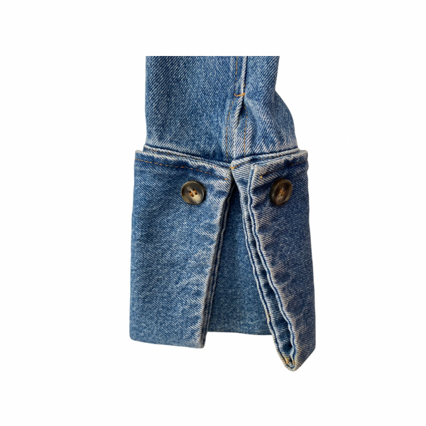 Close-up of a denim jacket with button details on a white background