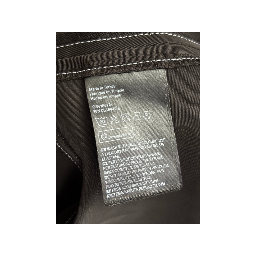 Clothing label with care instructions on a black fabric background